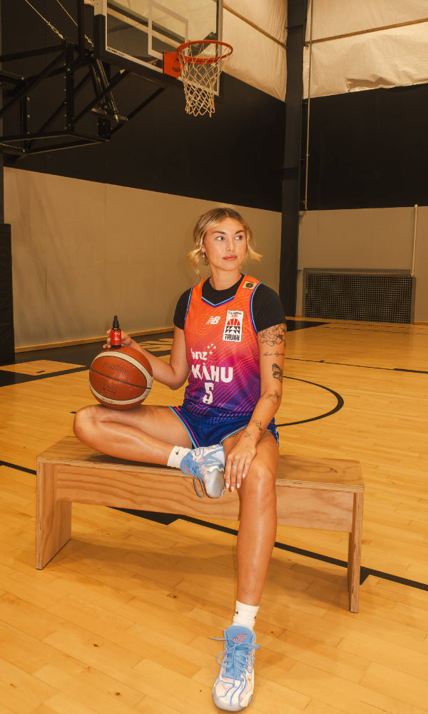 Person sitting on a basketball court holding a basketball