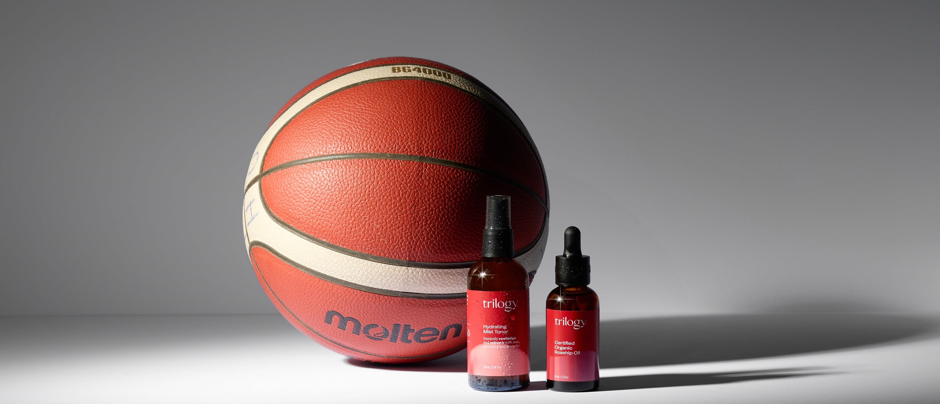Basketball and two bottles of Trilogy on a gray background